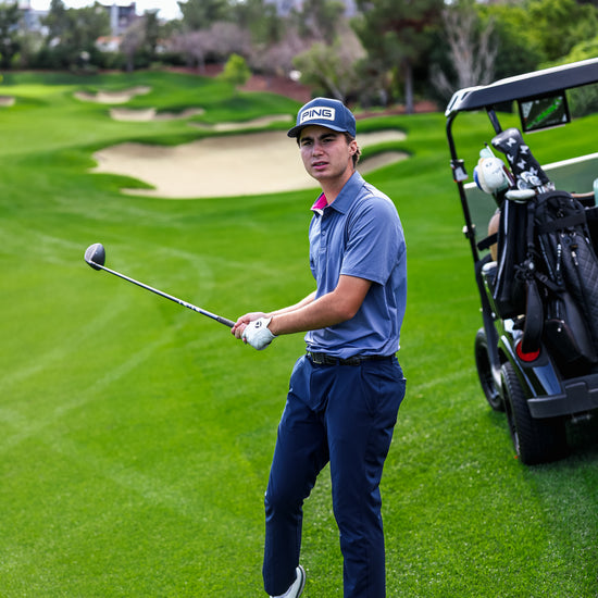 Golfer on a golf course with a caddie cart in the background