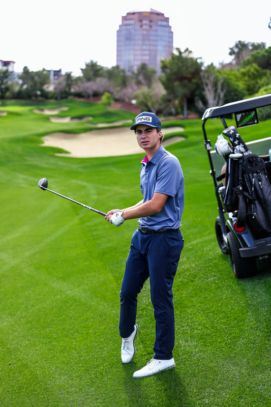 Golfer on a golf course with a caddie cart in the background